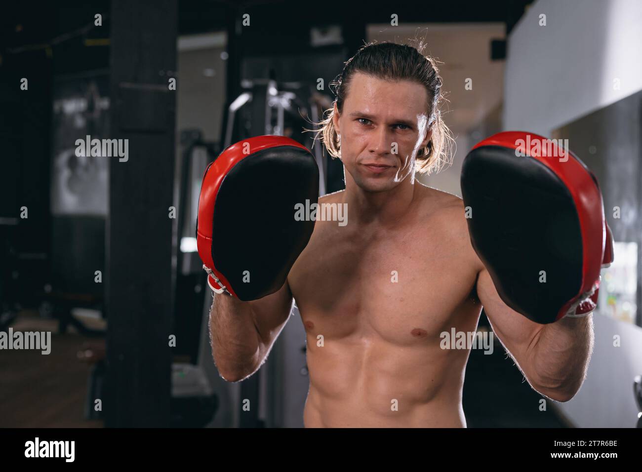kickboxing athlete trainer portrait with boxing pad glove in fitness gym sport action Stock Photo