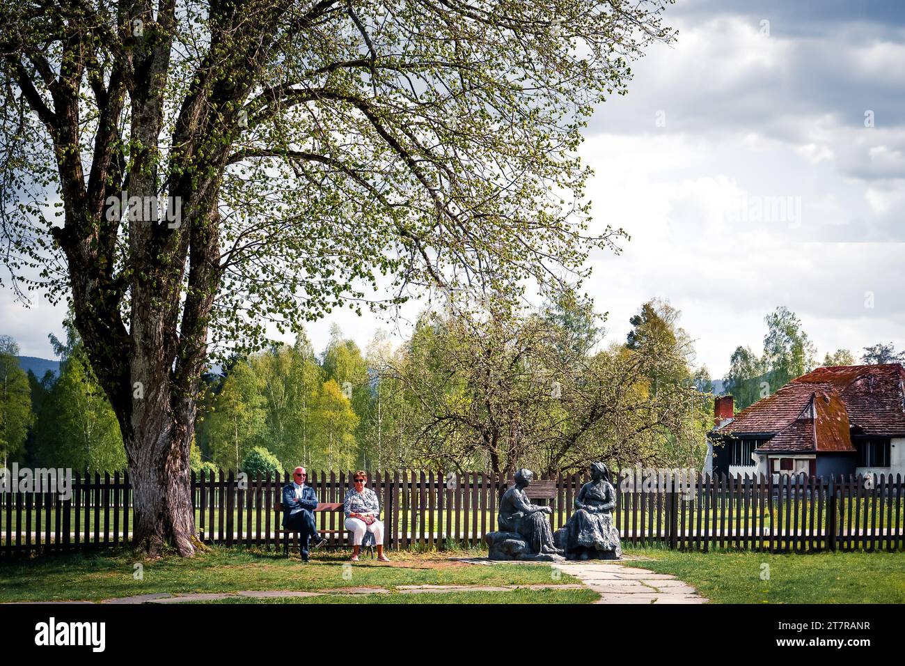 Couple resting by Heddal Stave Church park Stock Photo