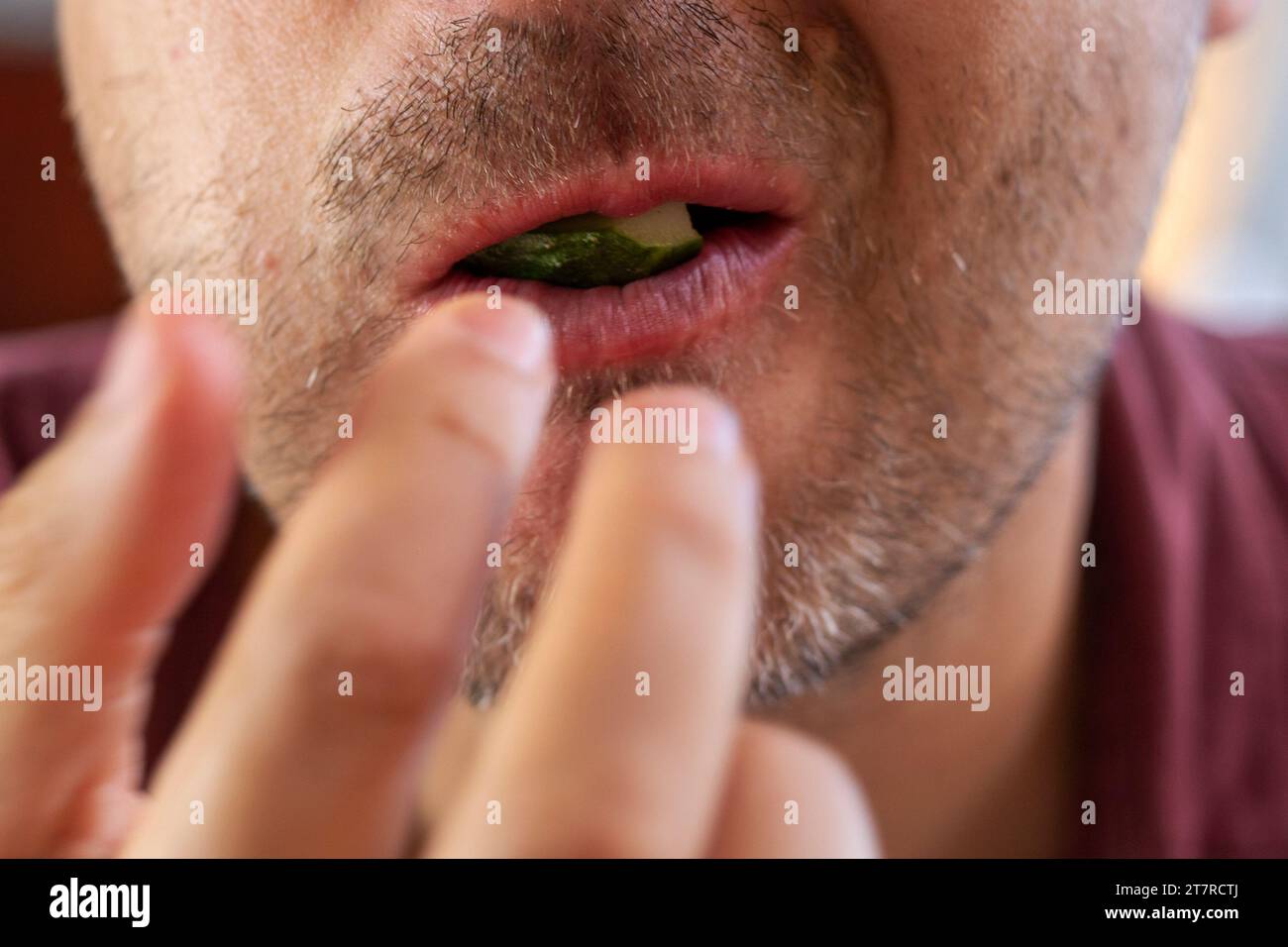 biting off a piece of fresh home grown cucumber with your teeth Stock Photo