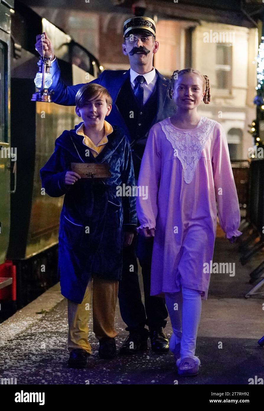 Actors playing the roles of characters from the Polar Express book, walk alongside the Polar 