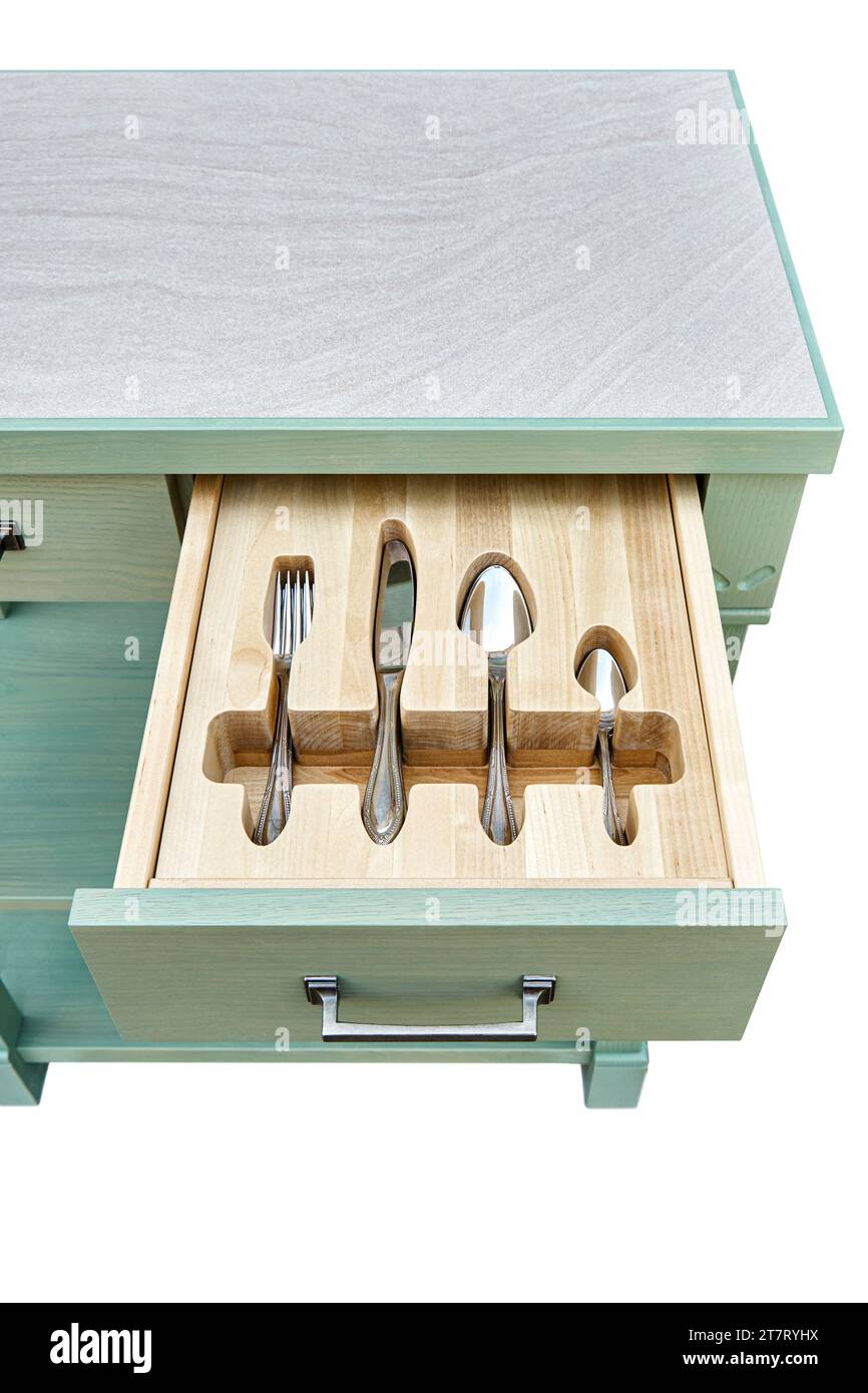 Shiny silverware in craved wooden tray in serving table drawer isolated on white background