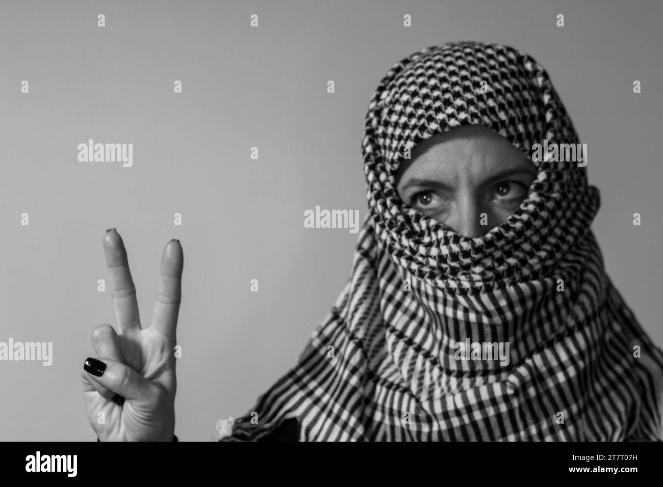 Green-eyed woman wearing a Palestinian scarf. Conflict concept Stock Photo