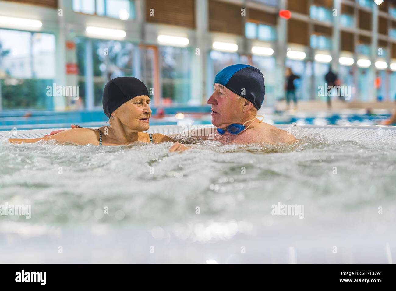 Elderly couple together in the jacuzzi spa hot tub, healthcare concept