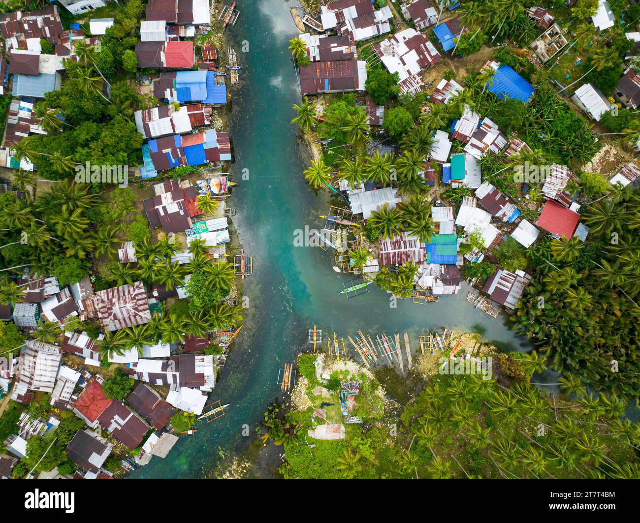 Houses and fishing boats along the Bogac Cold Spring in Surigao del Sur. Philippines. Stock Photo