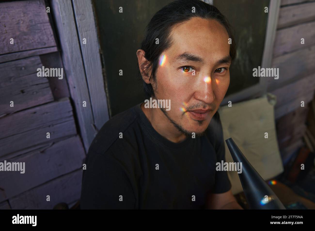 Portrait of a man, rainbow sun glare on his face, close-up Stock Photo