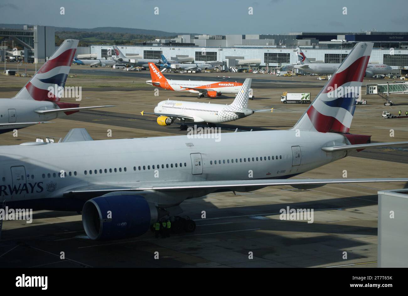 A view from the South Terminal at Gatwick Airport looking towards the North Terminal including the air bridge extension and a variety of aircraft Stock Photo