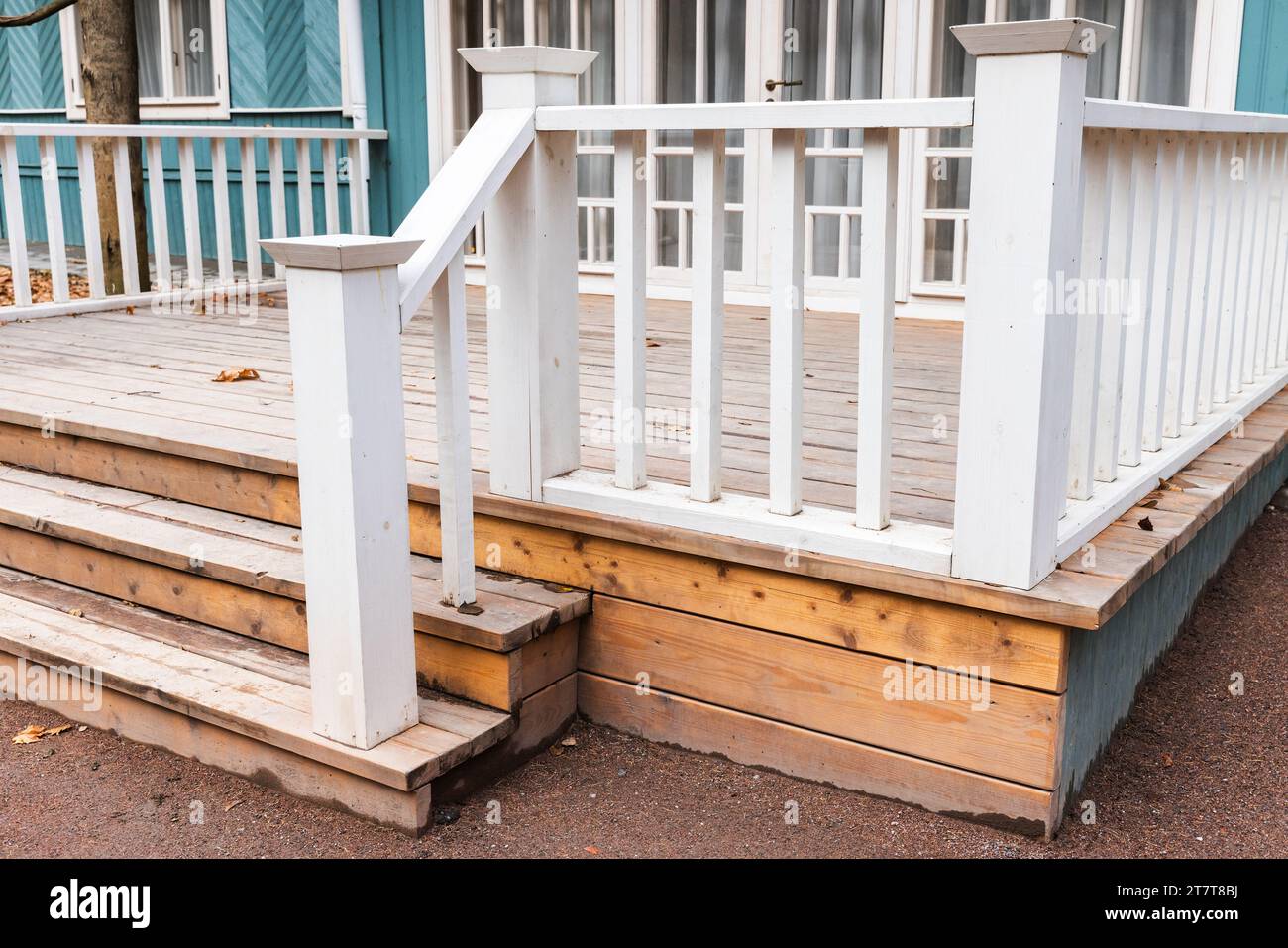 Backyard background photo with an empty wooden porch and stairs with white handrails Stock Photo