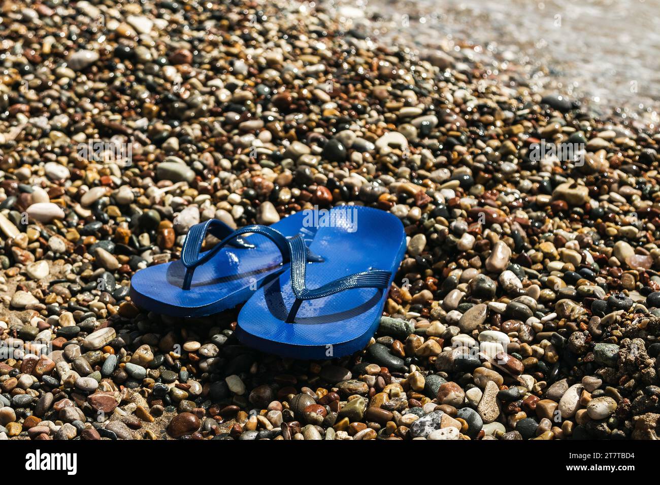 Wet blue rubber flip flops at the pebbly beach Stock Photo - Alamy