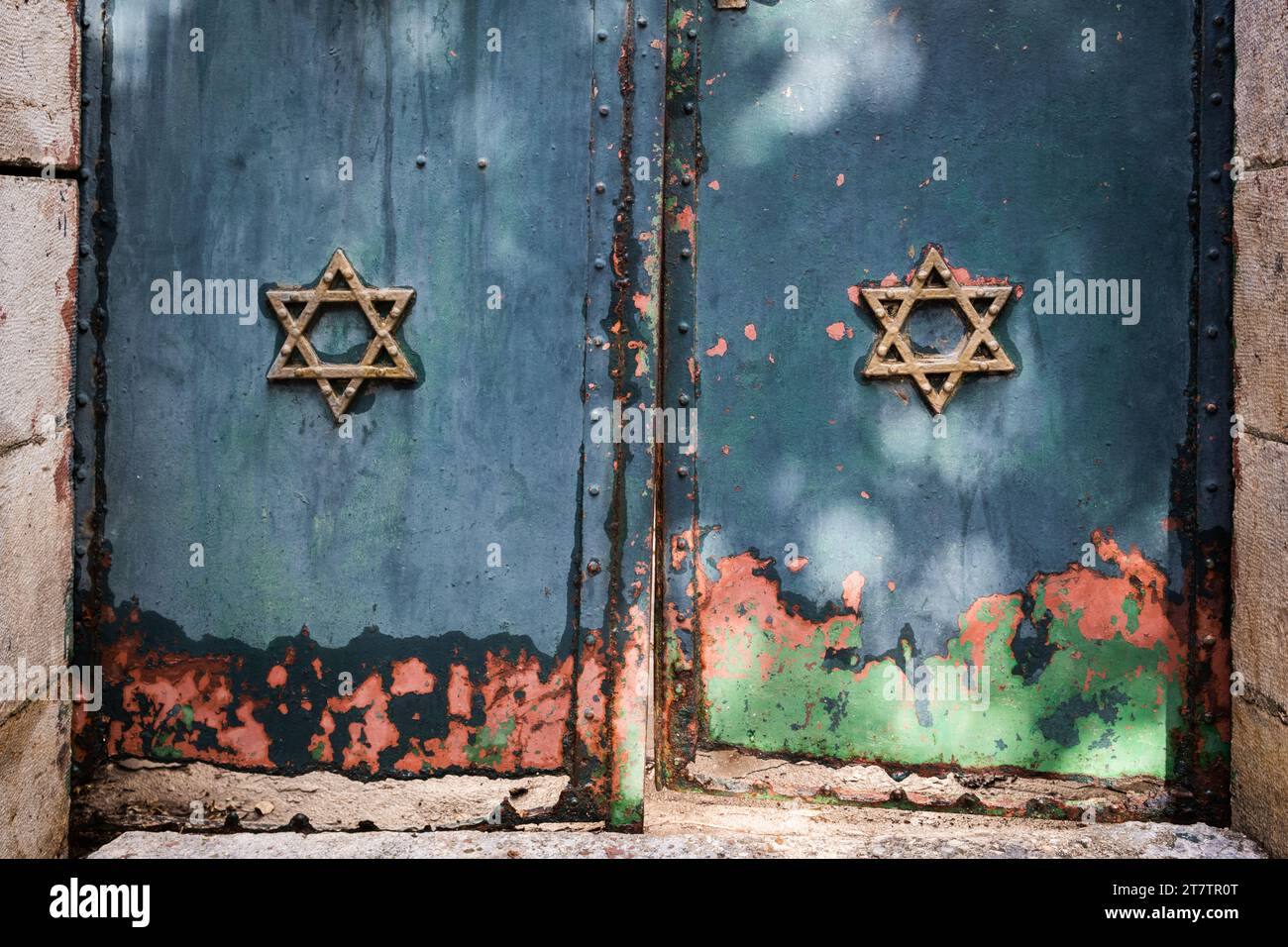 Gold Stars of David embossed on old metal doors with layers of multi-colored, peeling paint. Stock Photo