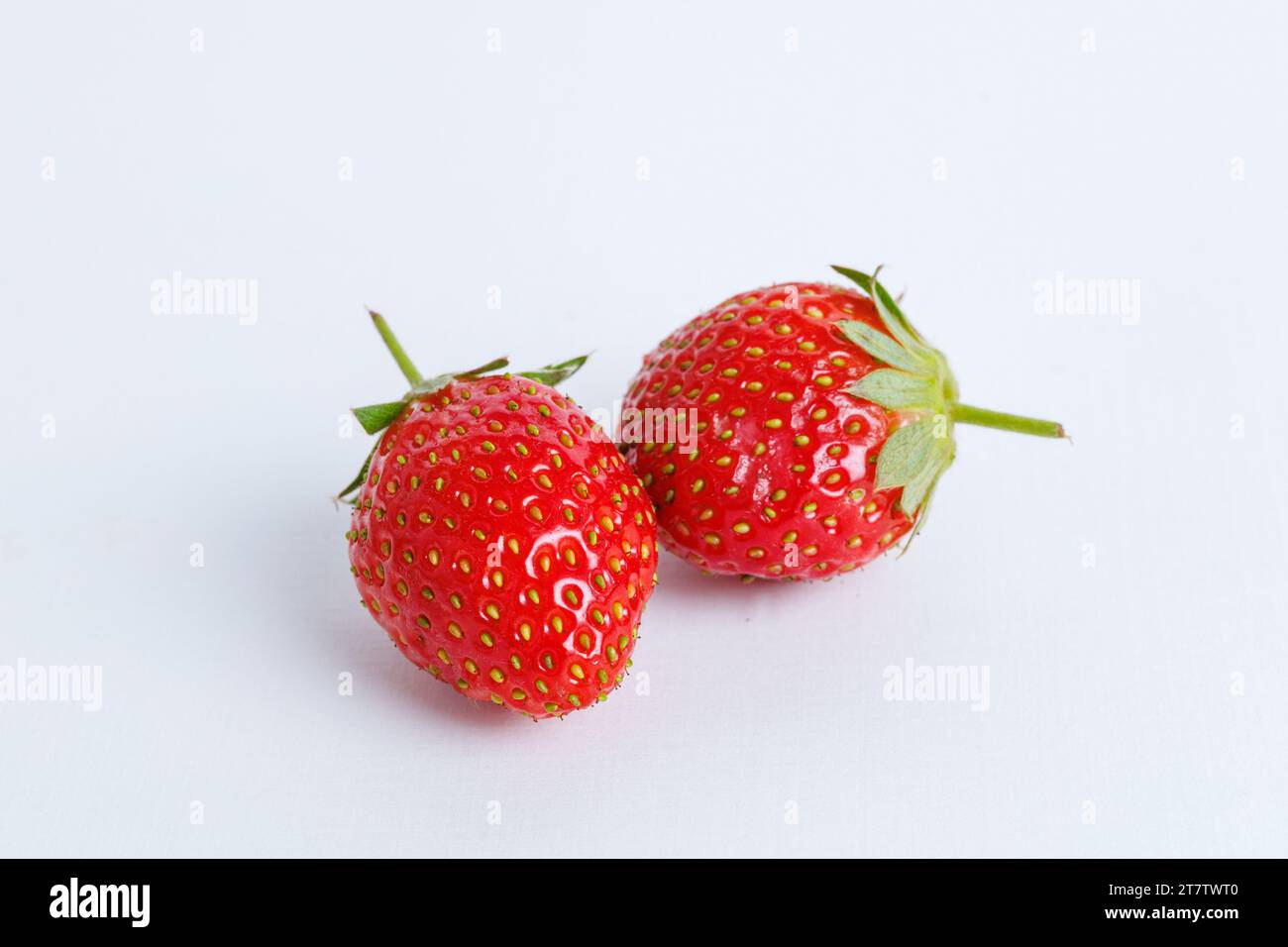 Two strawberries close up on white background Stock Photo - Alamy