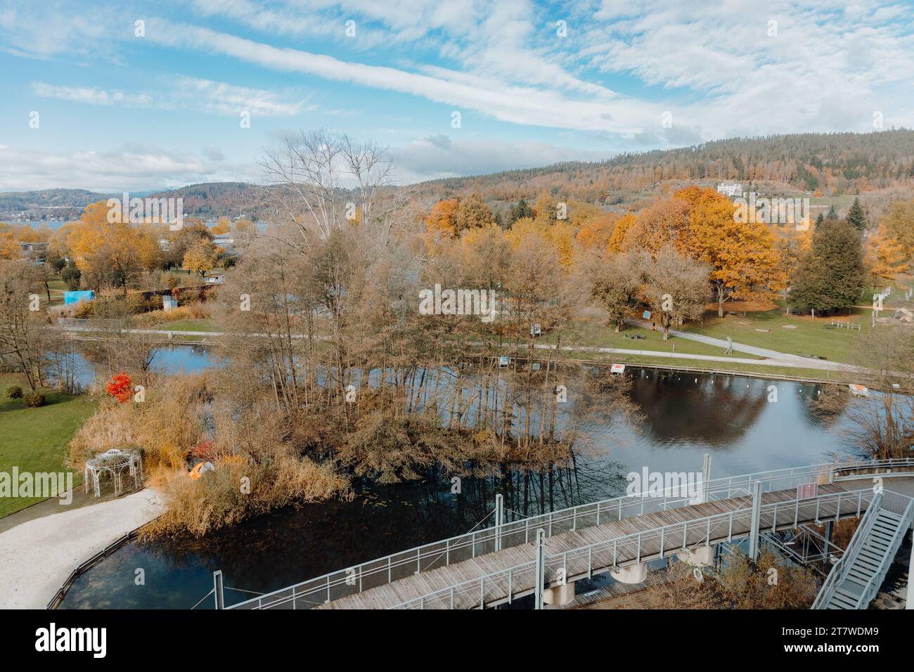 An aerial view of an autumn park with a tranquil lake and golden trees ...