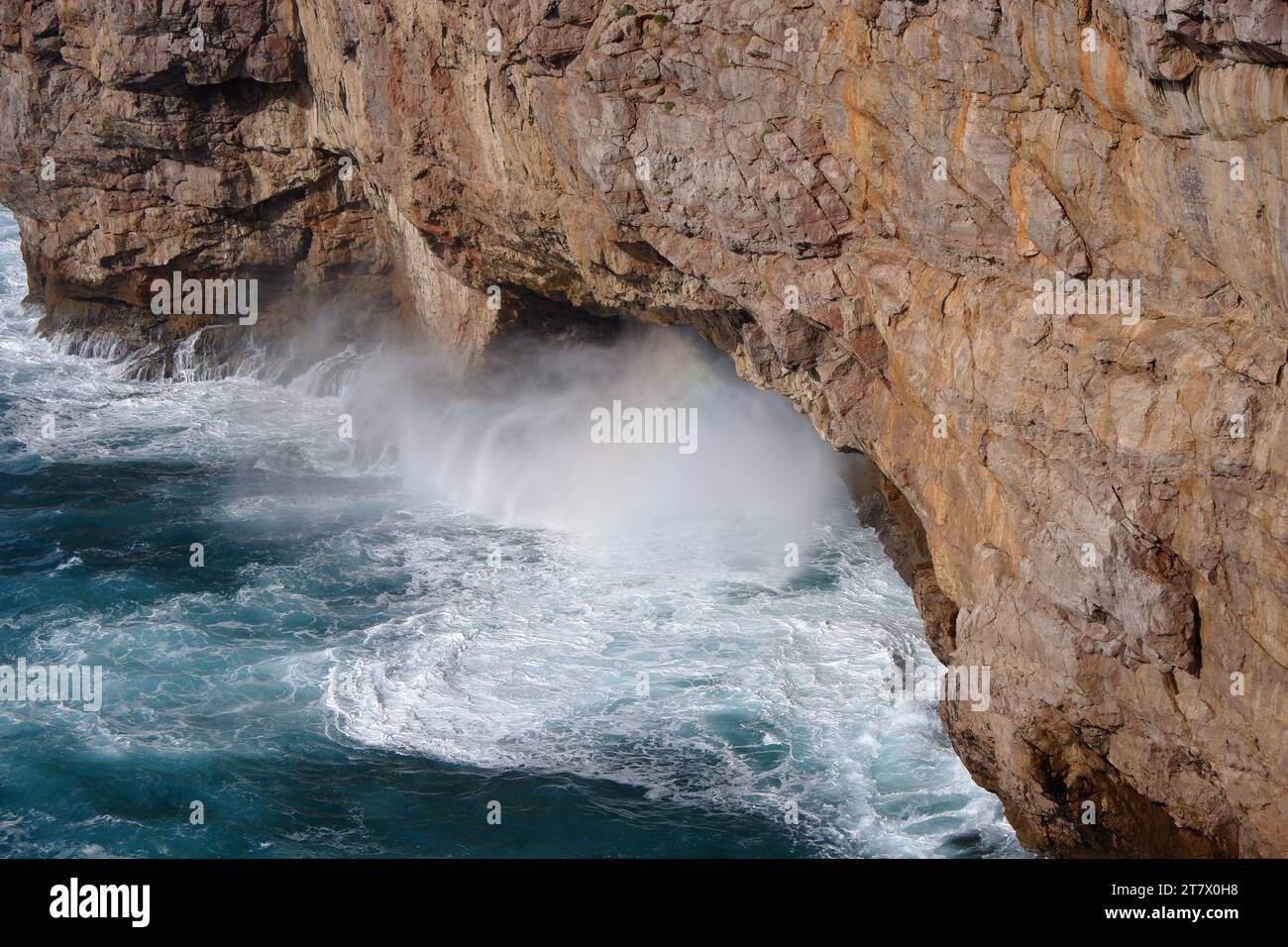 Water against cliff with rainbow effect Stock Photo