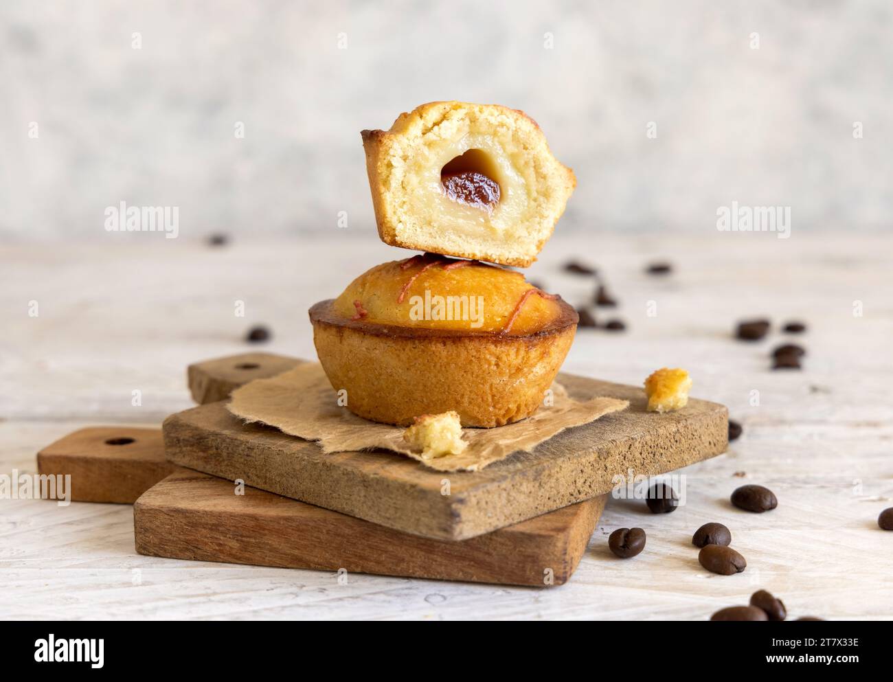 Pasticciotto leccese pastry filled with egg custard cream and sour cherry jam. Pieces of pasticiotto on a wooden board, typical apulian breakfast, clo Stock Photo