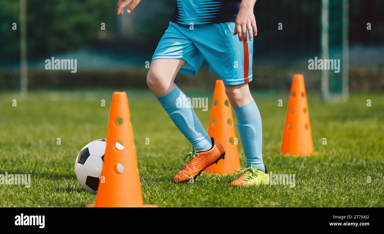 School physical education class for kids. Soccer ball control exercises for kids. Child playing soccer ball on practice unit. Football sports training Stock Photo