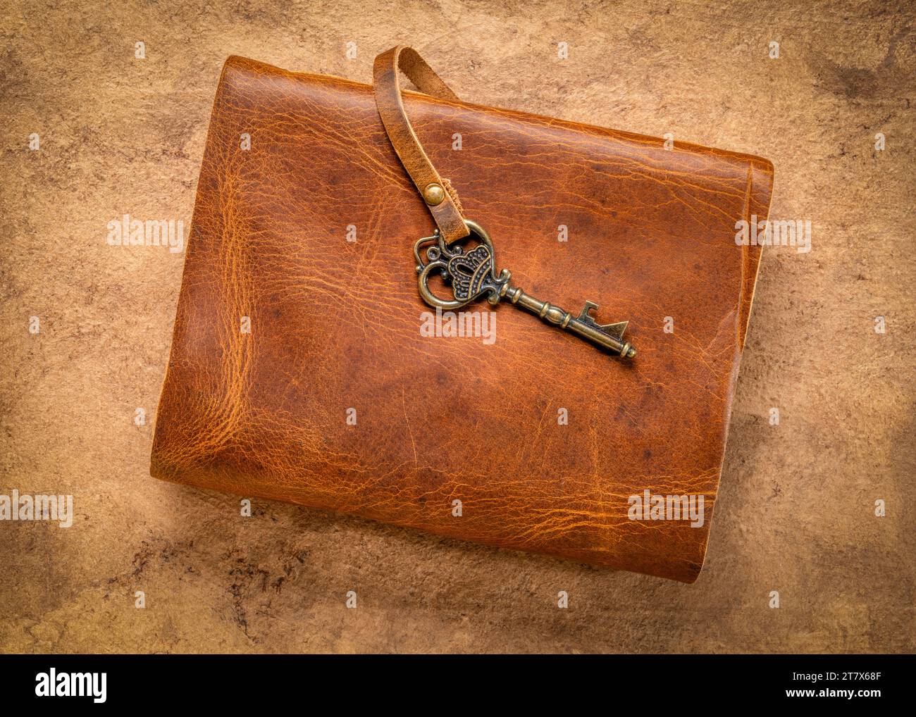 retro leather-bound journal with a decorative key on a handmade bark paper, journaling concept Stock Photo