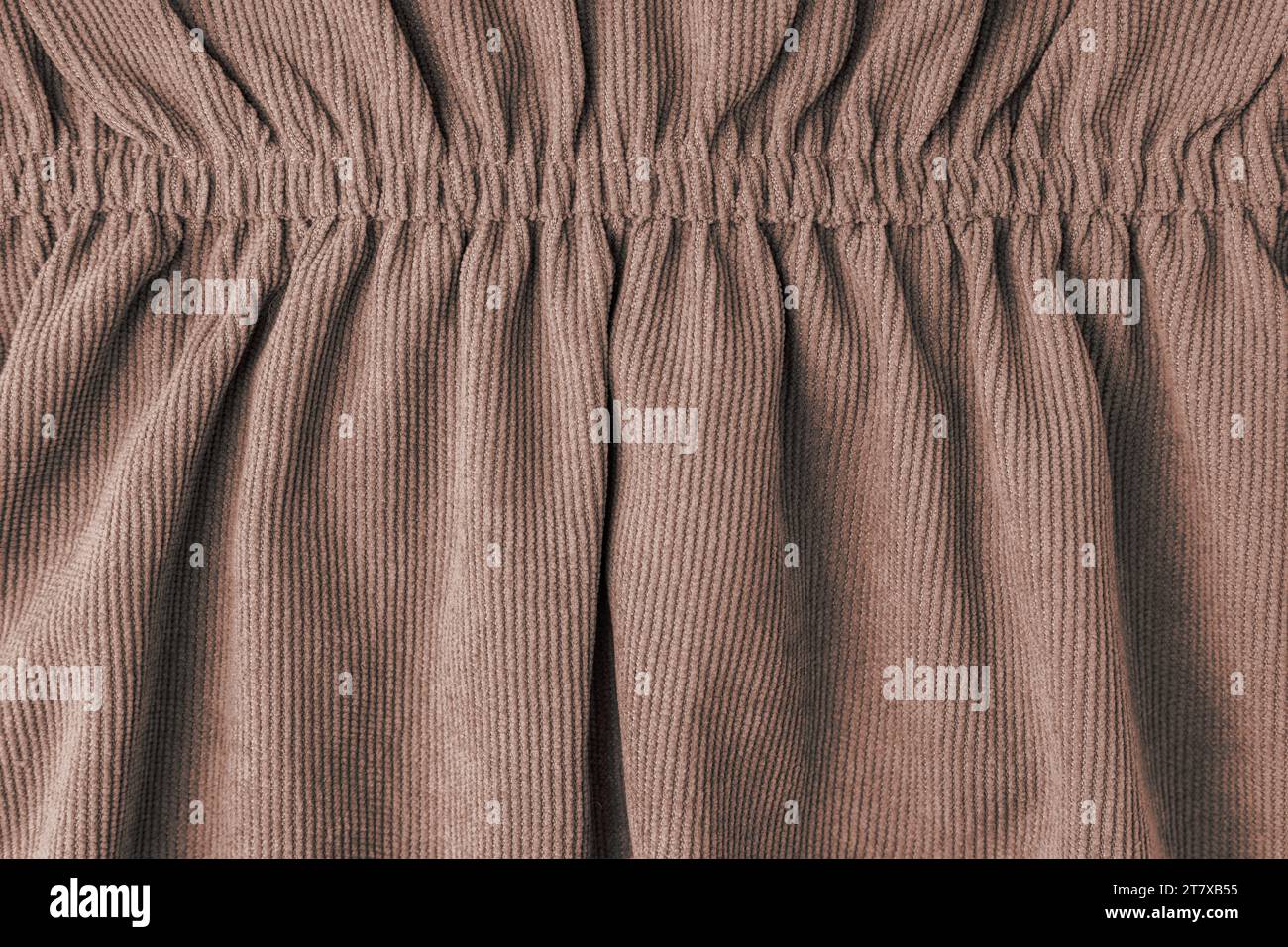 Brown corduroy fabric gathered with elastic close-up. Velveteen texture