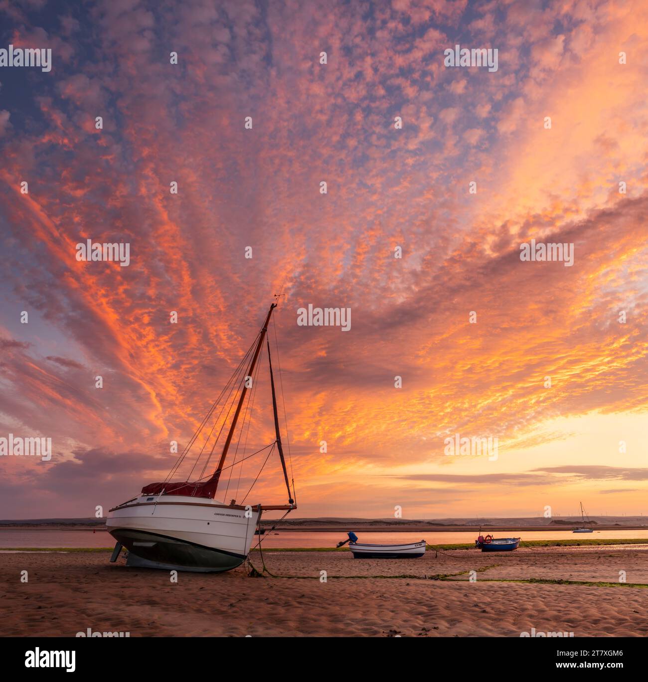 A spectacular late June sunrise, as the tide creeps towards the small boats that line the River Torridge estuary at Appledore in North Devon. Stock Photo