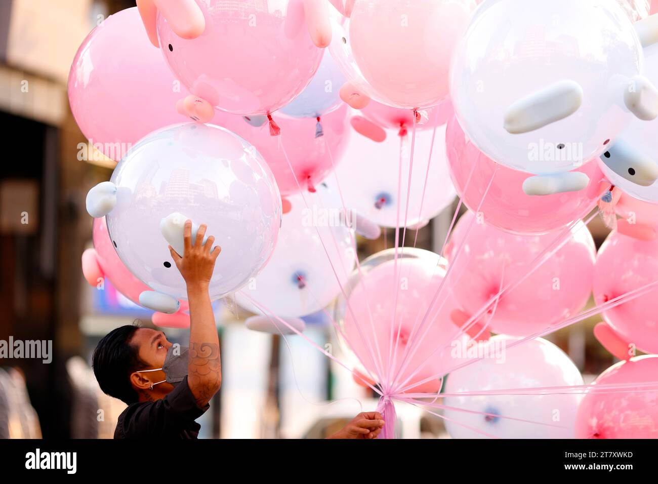 Man selling air pink balloon toys in street, Ho Chi Minh City, Vietnam, Indochina, Southeast Asia, Asia Stock Photo