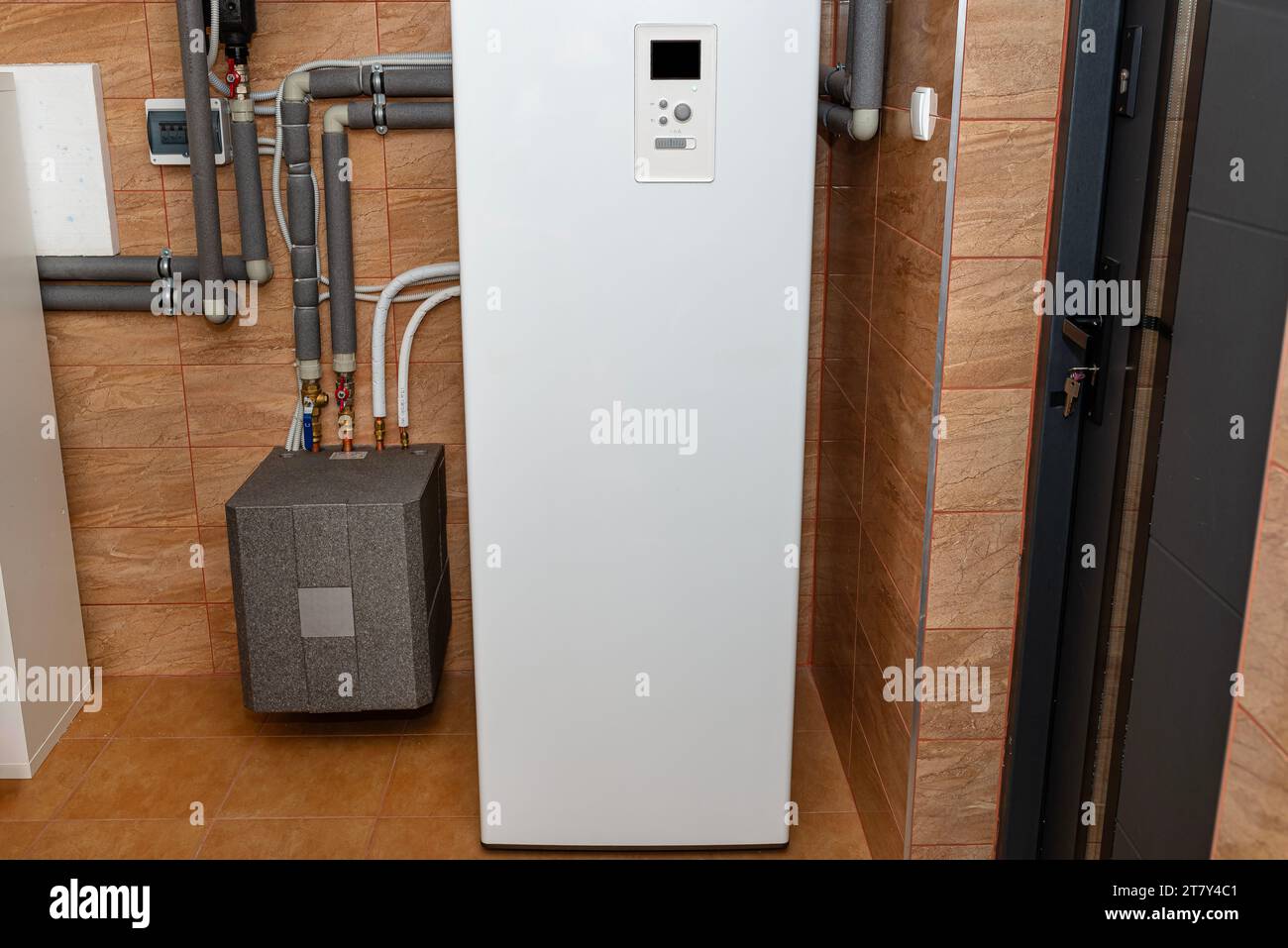 A modern air heat pump installed in the home's boiler room, visible