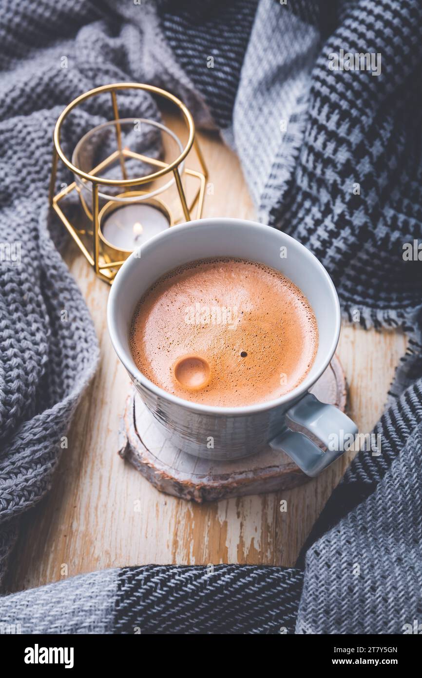 Fall season, leisure time, morning cocoa, sunday relax, hygge and still life concept. Cup of hot cocoa with candle, warm knitted scarf and sweater Stock Photo
