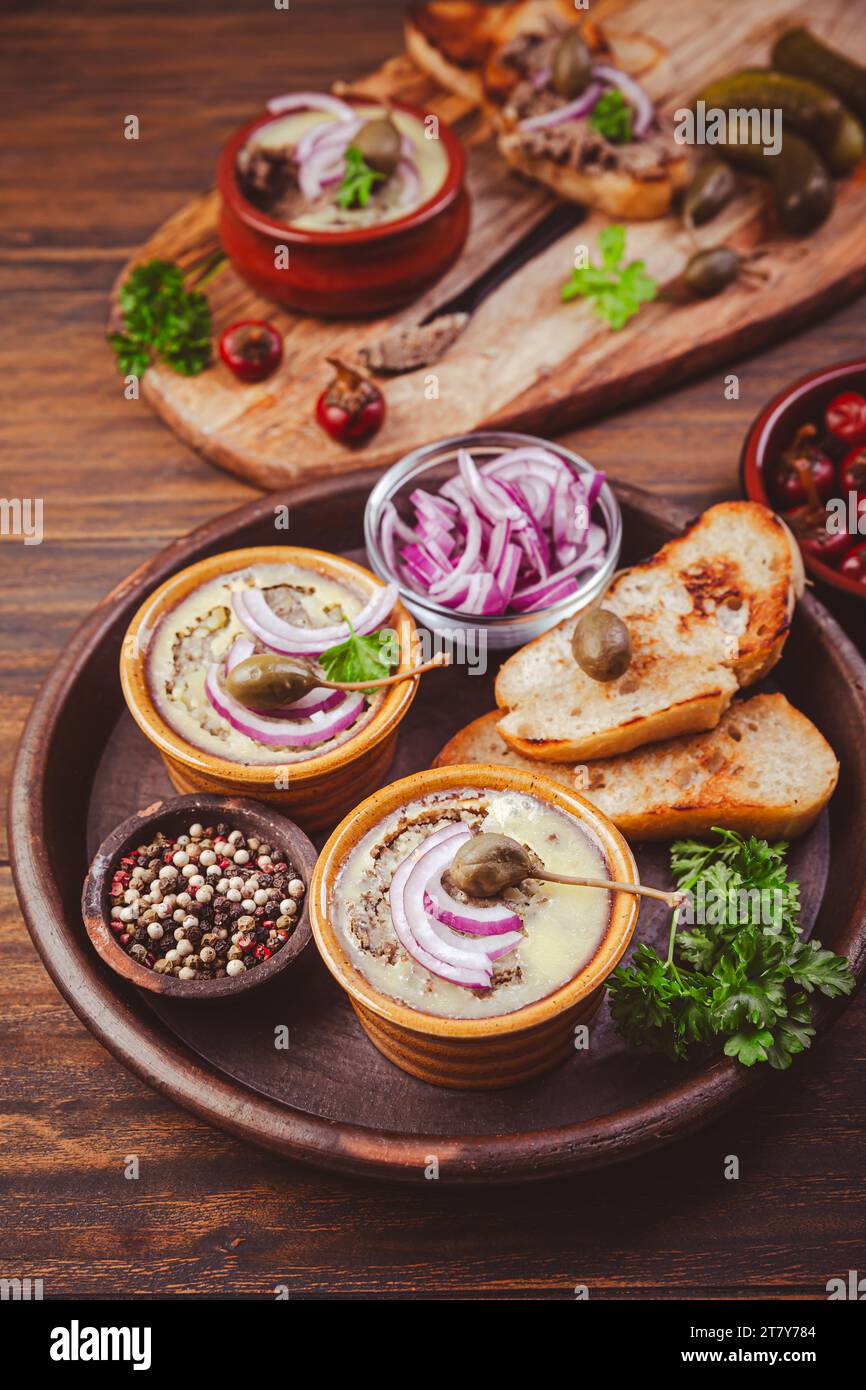 Fresh homemade chicken liver pate in ceramic bowls and appetizers on rustic background Stock Photo