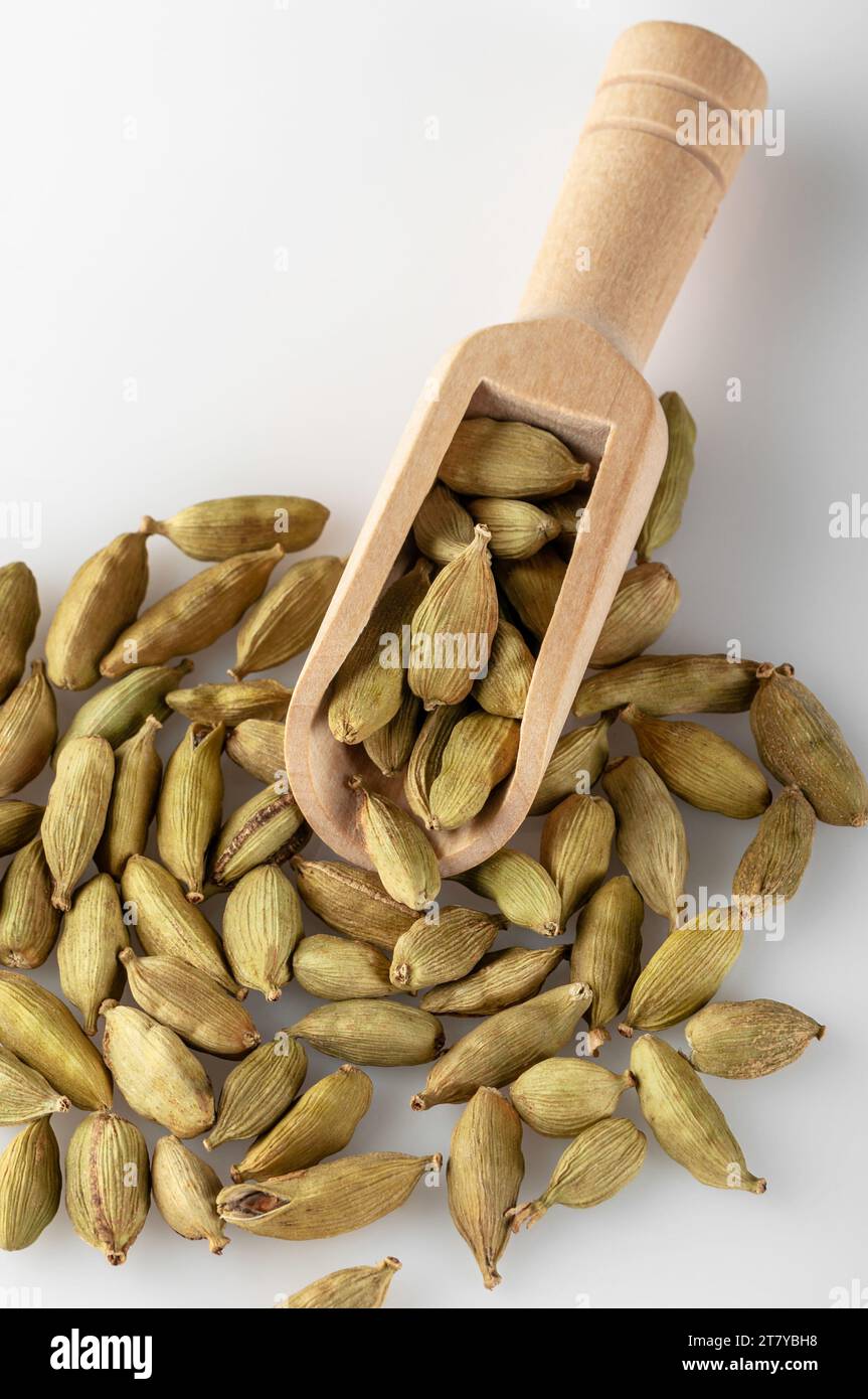Cardamom seeds lie in a wooden scoop. Cardamom seeds used for making