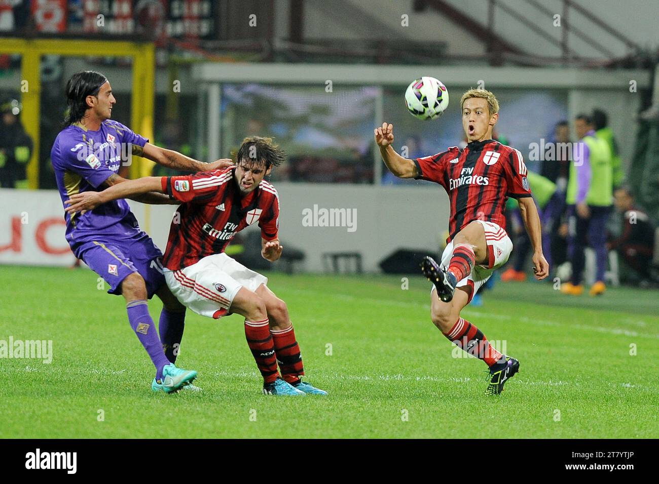 Keisuke Honda of AC Milan controls the ball while team mate Andrea Poli holds off Alberto Aquilani of ACF Fiorentina during the Italian Championship Serie A football match between AC Milan and ACF Fiorentina at Giuseppe Meazza Stadium on October 26, 2014 in Milan, Italy. Photo Massimo Cebrelli / DPPI Stock Photo