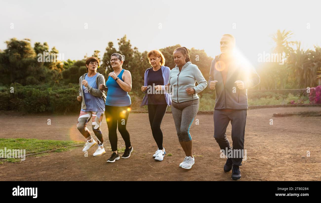 Group of diverse senior friends jogging together at park Stock Photo