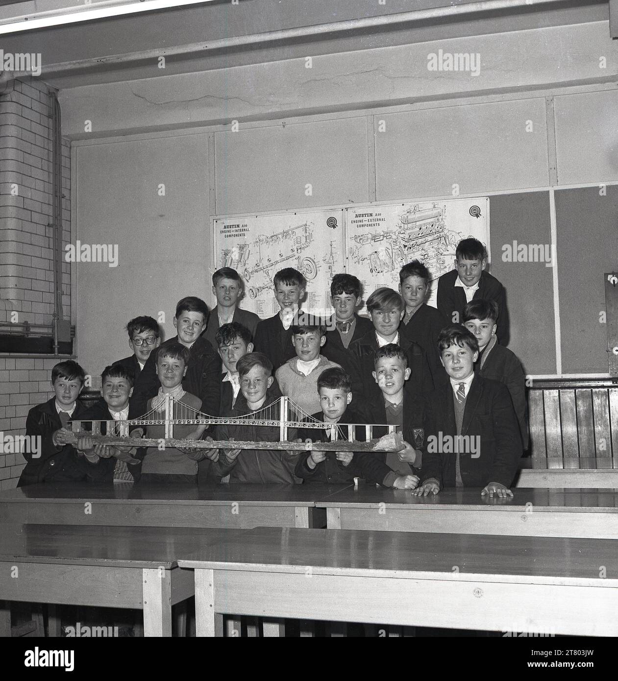 1965, historical, a group of schoolboys in a classroom gathered together for a photo showing their model of the Forth Road Bridge, Fife, Scotland, UK. When the suspension bridge opened in 1964, it was the longest suspension bridge in the world.  Behind the boys, on the wall, diagrams for the engine of an Austin A99, a popular motorcar of the era. Stock Photo
