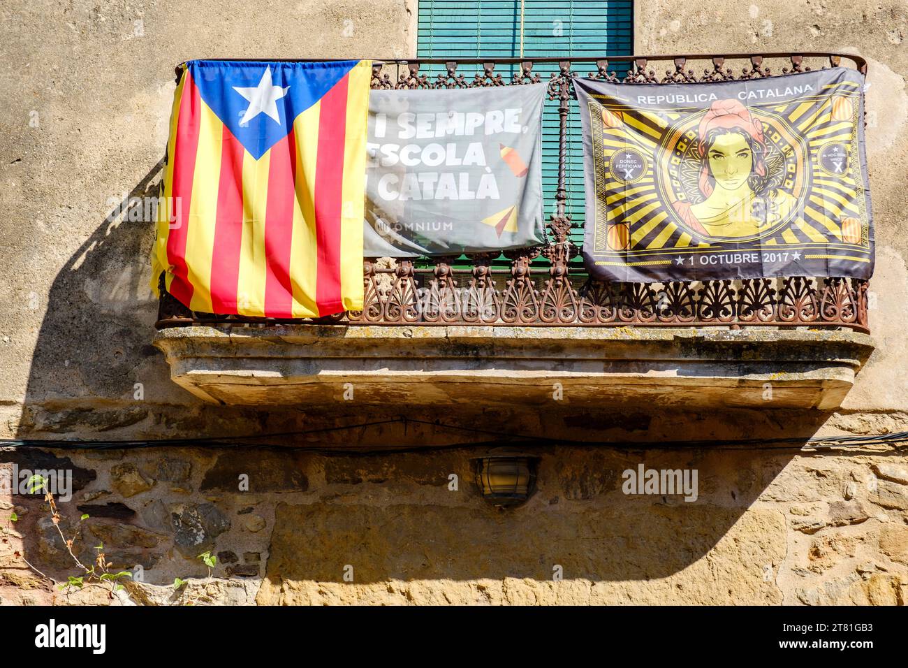 Catalan estelada unofficial star flag and banner promoting Catalunya independence hanging from a balcony in the village of Pals, Catalonia, Spain Stock Photo