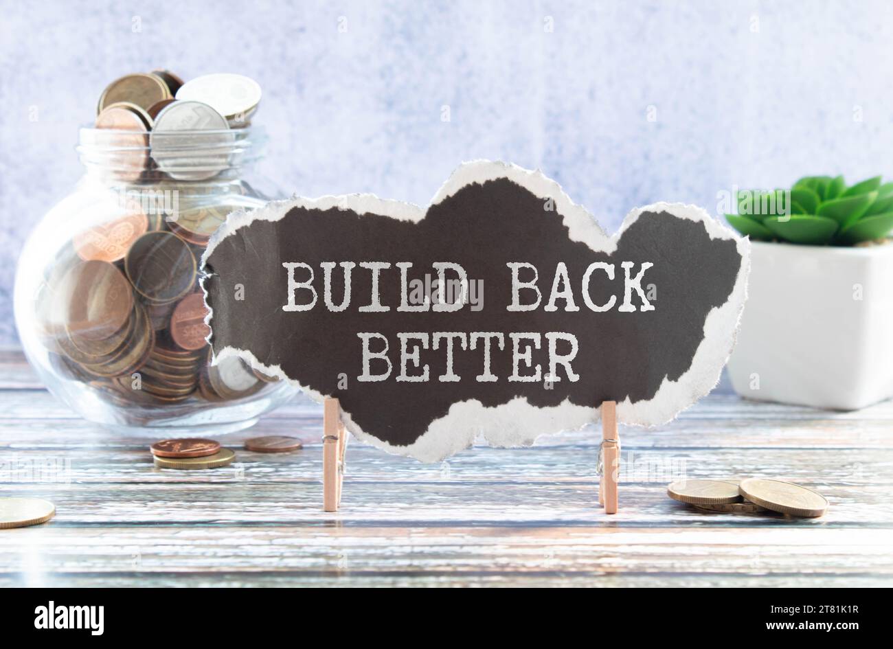 Build back better text on a notepad page on a gray background near banknotes and a magnifying glass. Stock Photo
