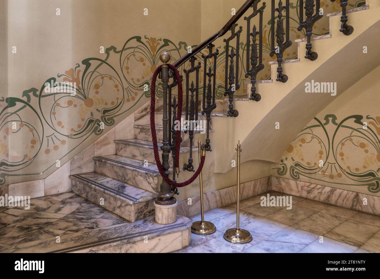 Staircase with wrought iron balustrade and functional railing, walls decorated with a border of ornamental paintings. House of the Snails, Castello. Stock Photo