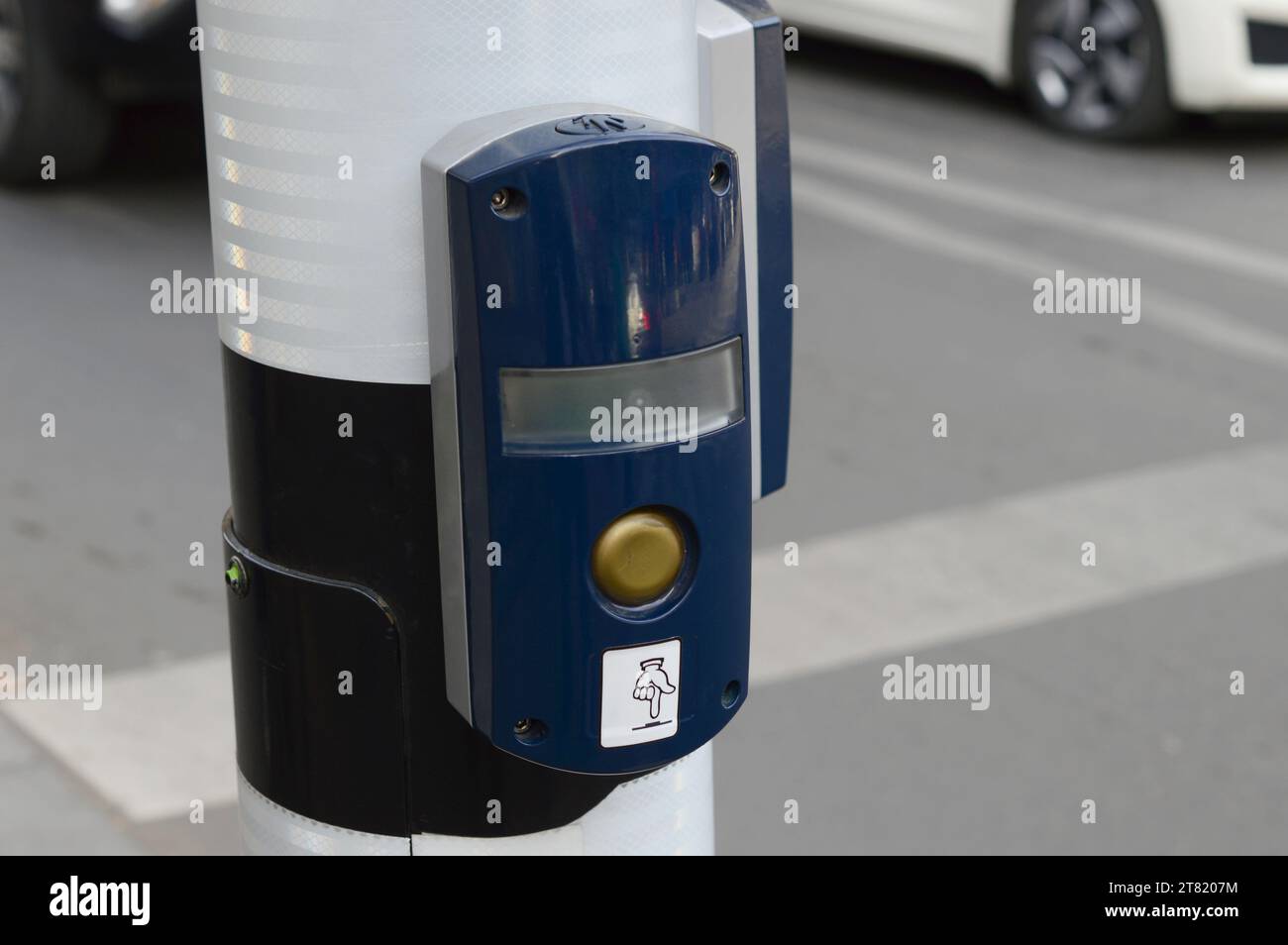 Traffic light switch button installed on the pole on the sidewalk for