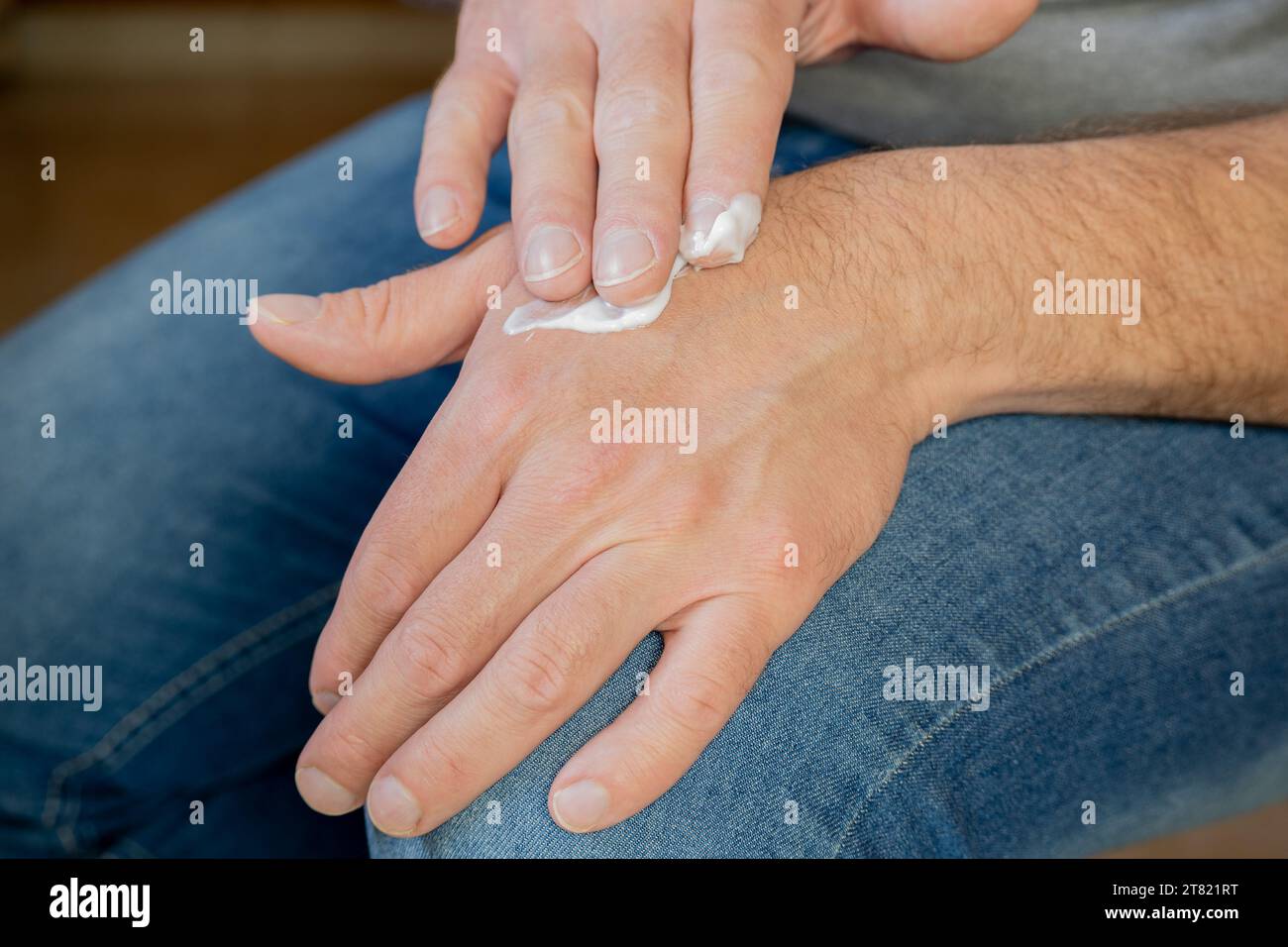 Hands of a man applying cream. Stock Photo