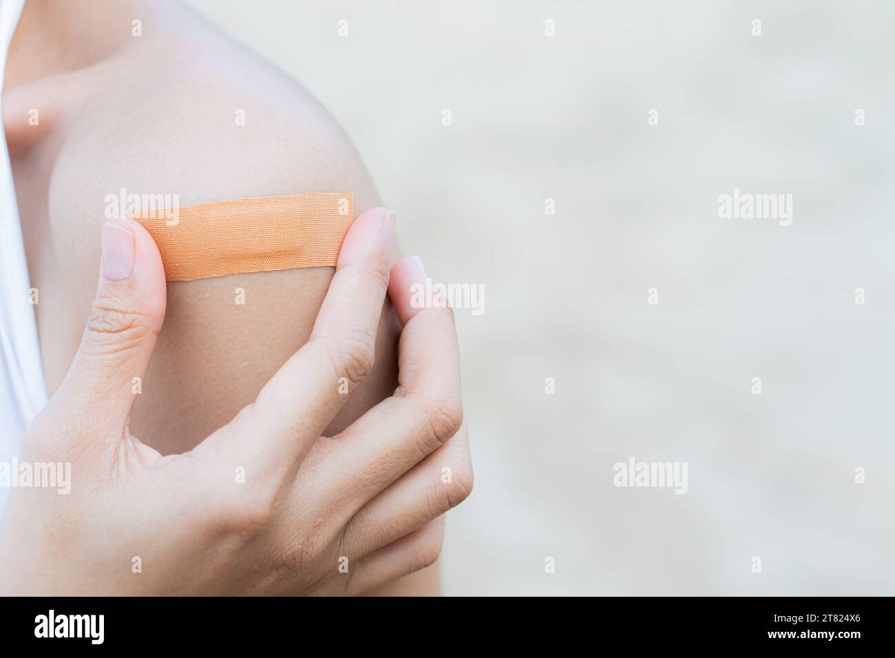 Closeup Of Human Hand Sticking Plaster Adhesive Bandage To Wound