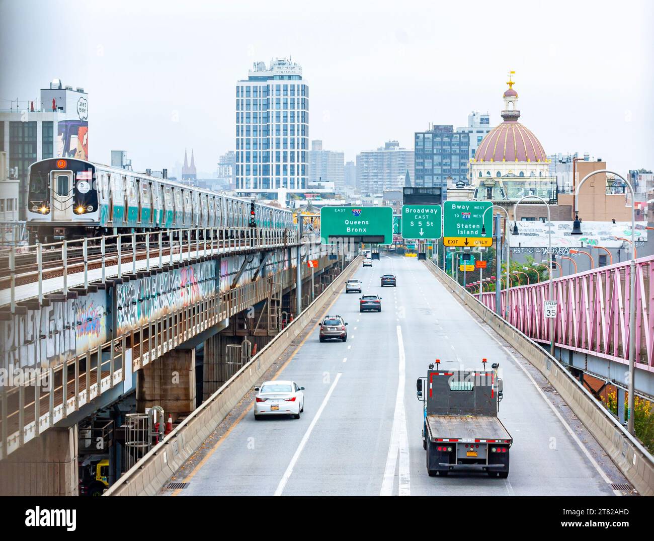 A subway train and traffic on the Williamsburg Bridge between Manhattan and Brooklyn, New York City, taxi heading to Queens and the Bronx Stock Photo