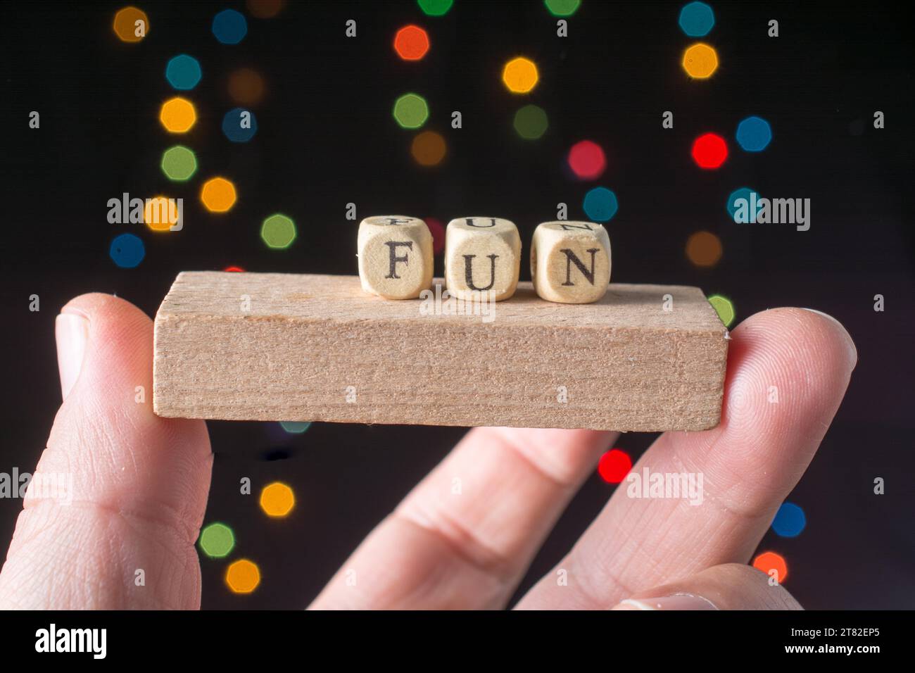 Fun wording in hand cubes bokeh lighton a dark background Stock Photo