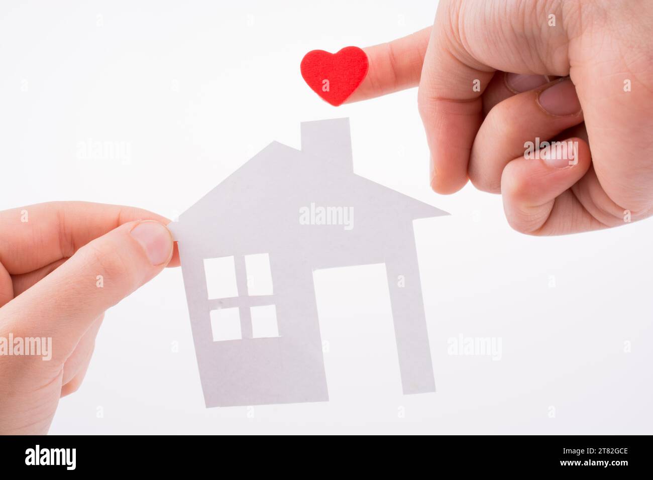 Paper house and heart shape in hand on a white background Stock Photo ...