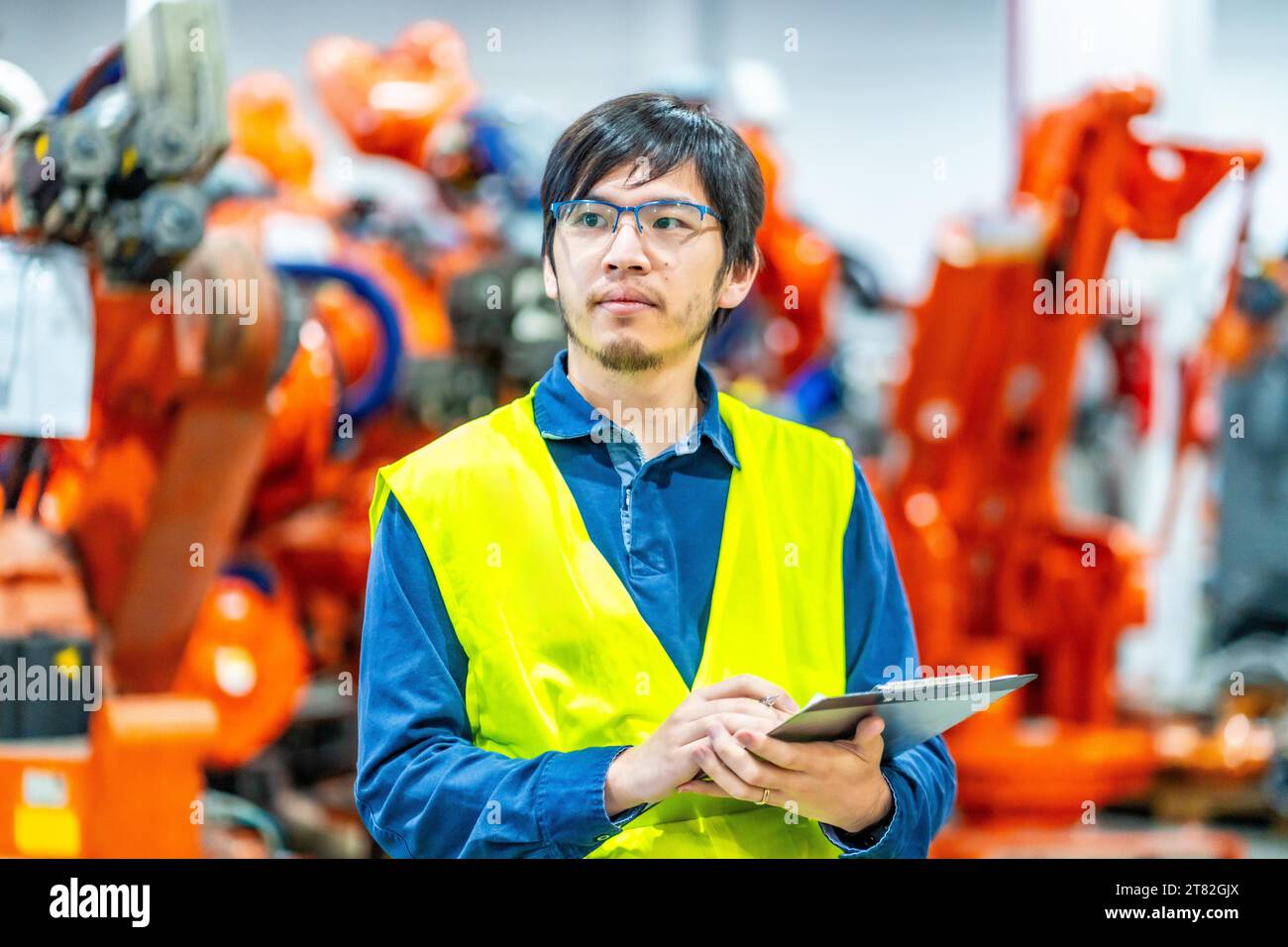 Engineer controlling the line of production of a robotic arms Stock Photo
