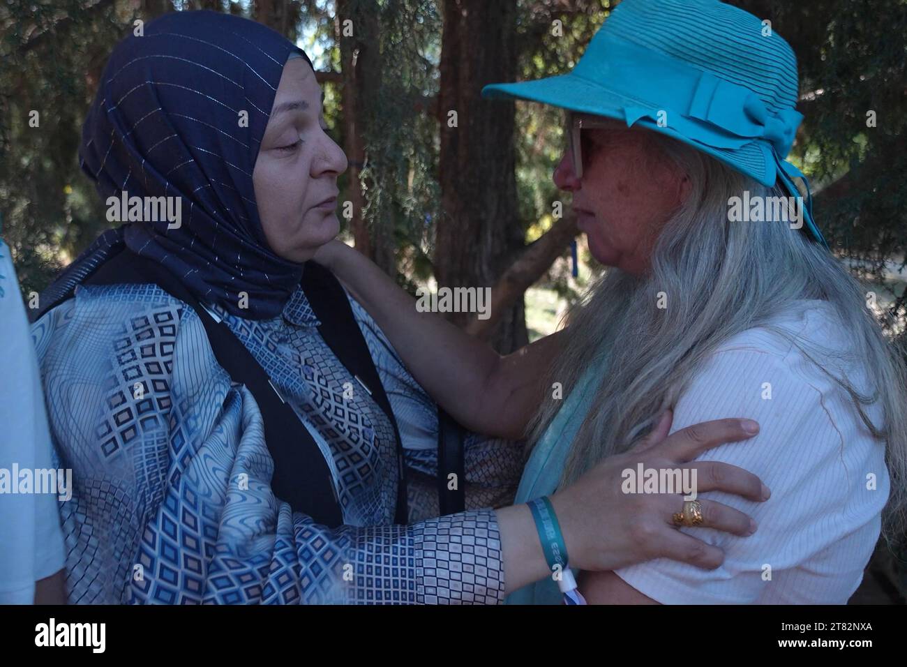 Arab-Israeli, Amira Zidan, and a Jewish woman comfort each other during a memorial service, as friends and family mourn Vivian Silver, a Canadian-born Israeli activist who devoted her life to seeking peace with the Palestinians, who had been presumed kidnapped by Hamas, but recently declared dead after her remains were found at her home in Kibbutz Be'eri; during a memorial service on November 16, 2023 in Tel Gezer, Israel. Stock Photo