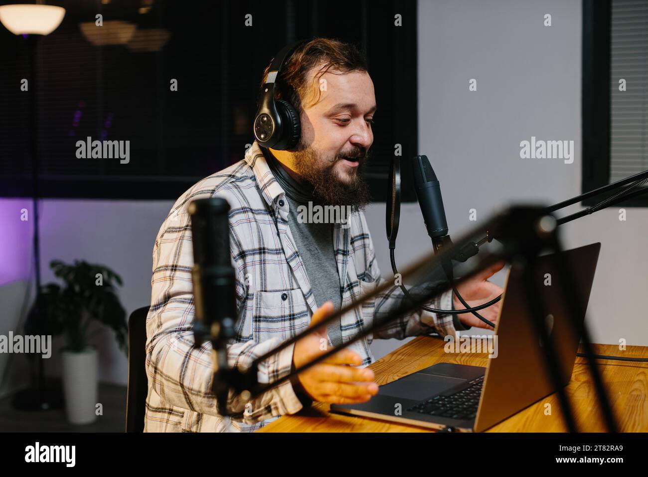 An online blogger speaks into a microphone during a stream. Radio presenter  in the studio during the broadcast Stock Photo - Alamy