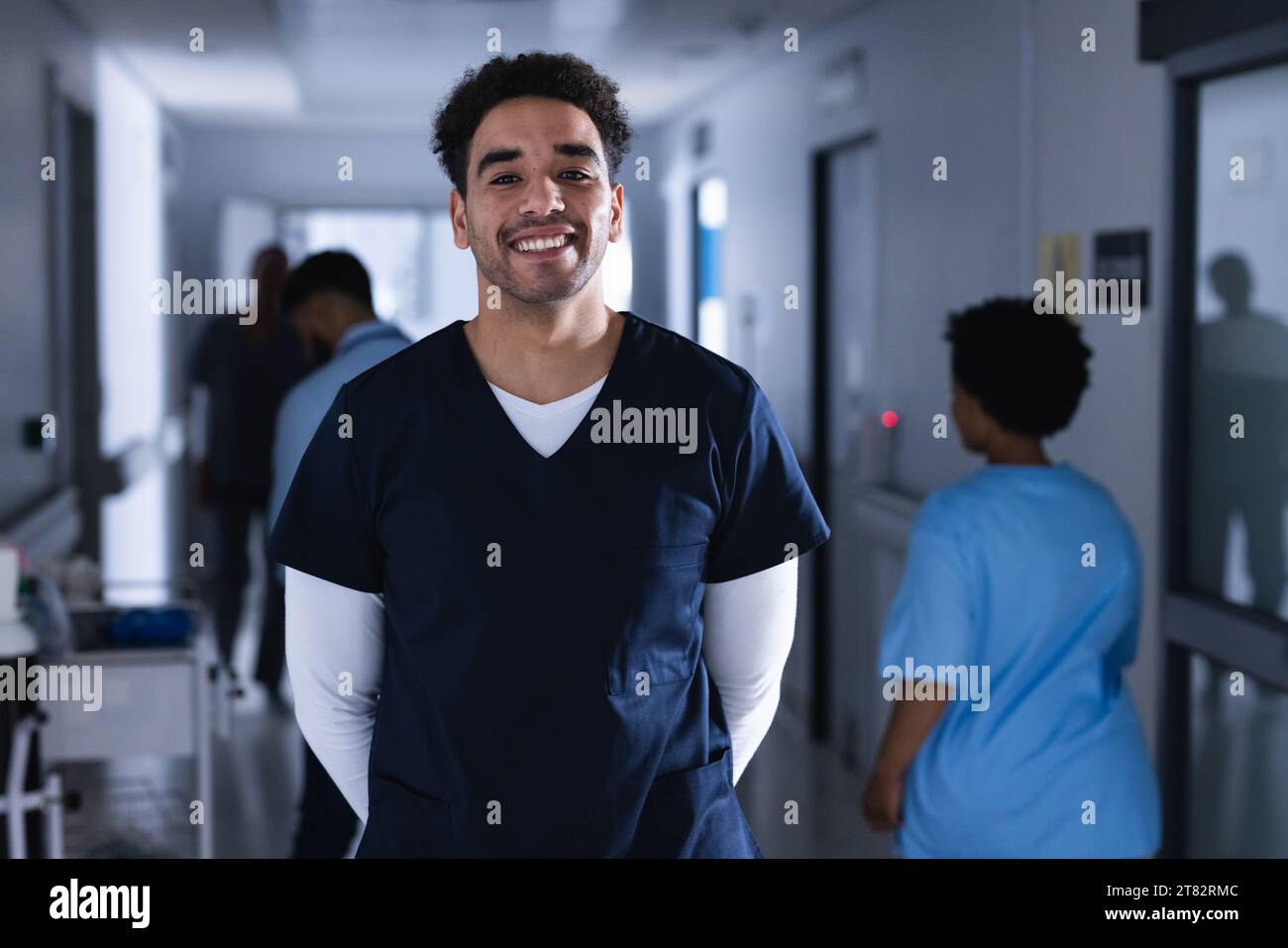 Happy doctor standing in hospital corridor hi-res stock photography and ...