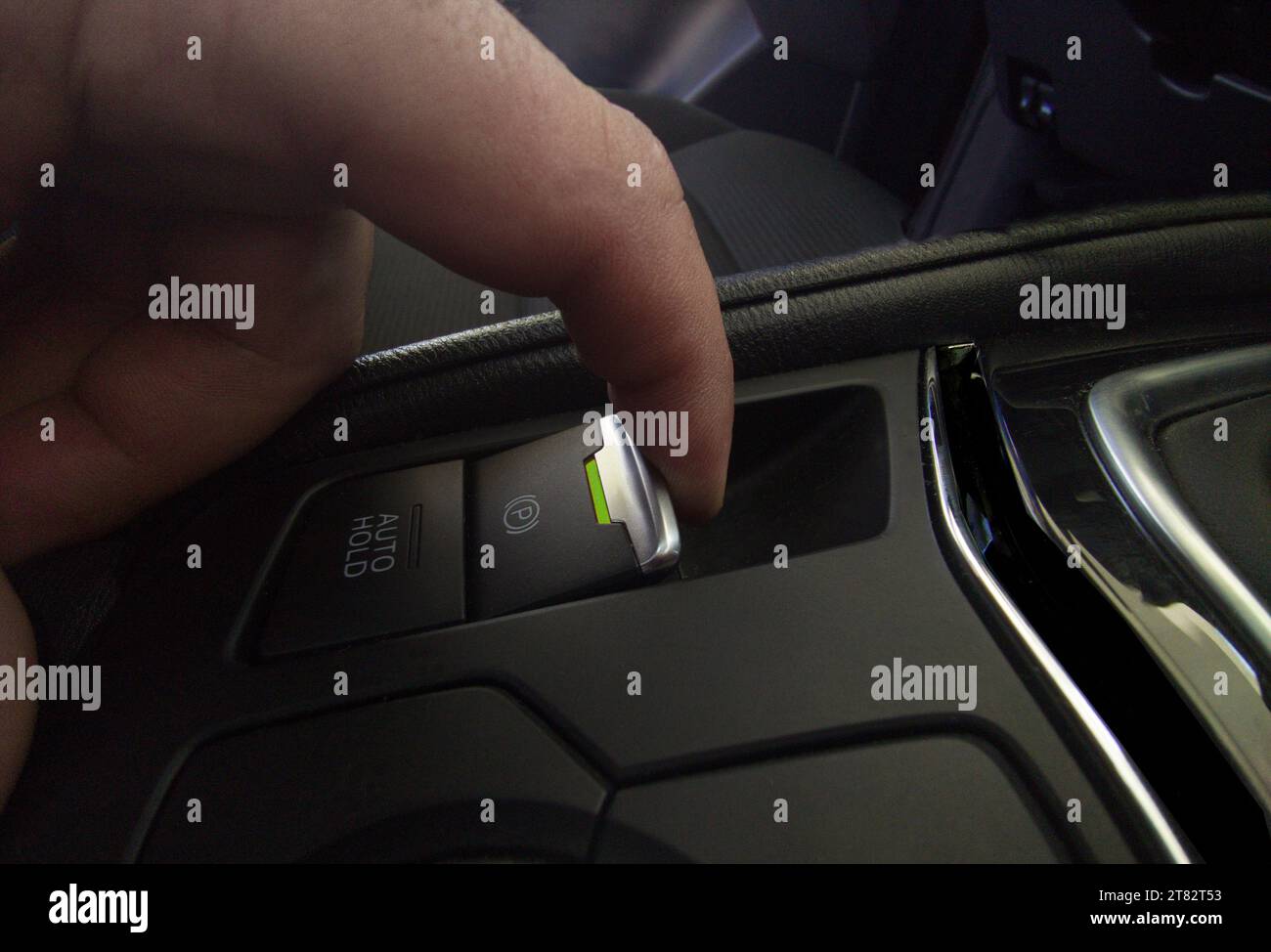 Driver pulling the electric parking brake of his car. Green color light