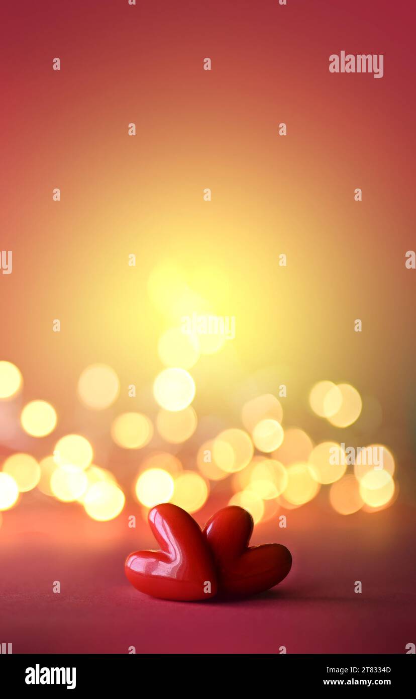 Two red valentines plastic hearts on red background. Stock Photo