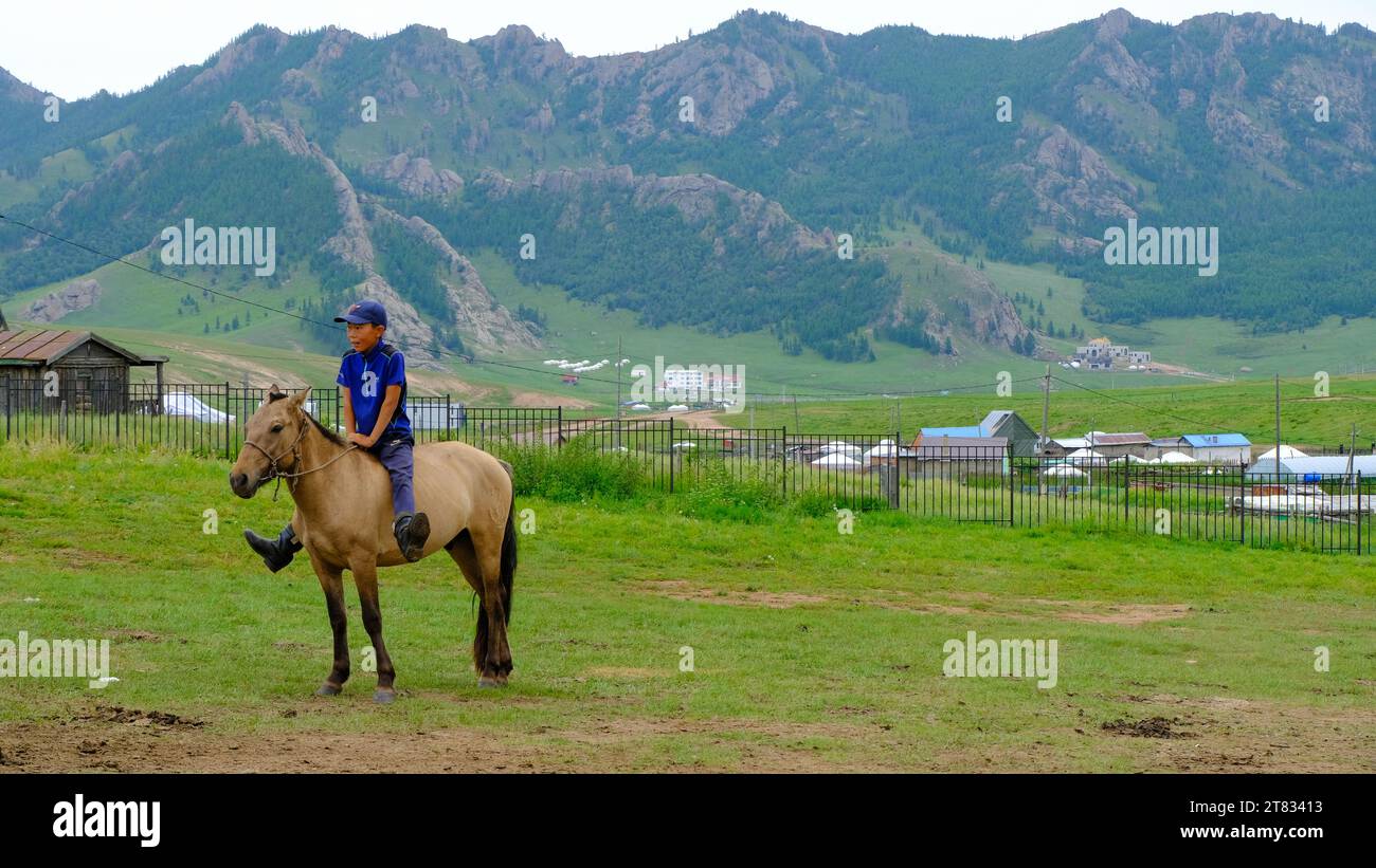 A boy riding a horse at Gorkhi-Terelj, a national park in Mongolia, not far from the birthplace of Genghis Khan, the founder of the Mongol Empire Stock Photo