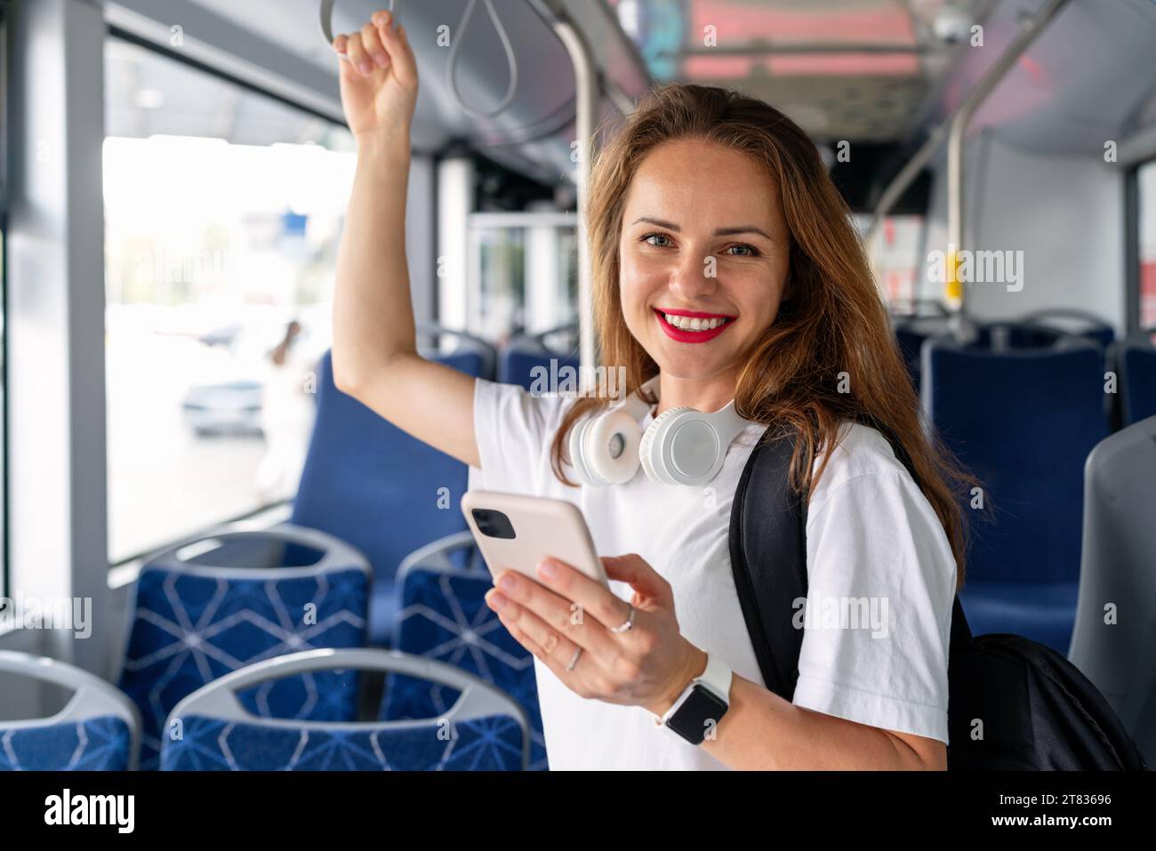 Portrait of young urban woman inside the bus. Public transportation passenger in the city. Stock Photo