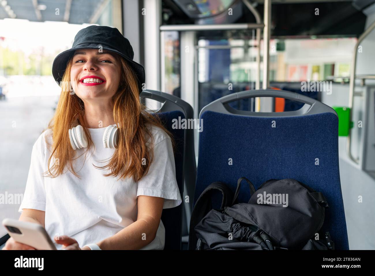 Joyful woman traveling around the city by bus. Passenger and public transportation in the city. Stock Photo