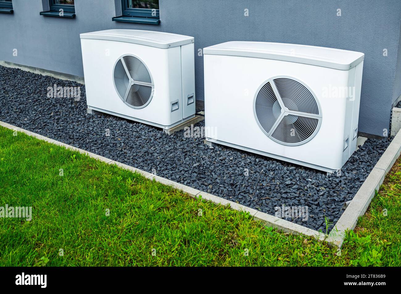 Two air source heat pumps installed outside of new and modern city