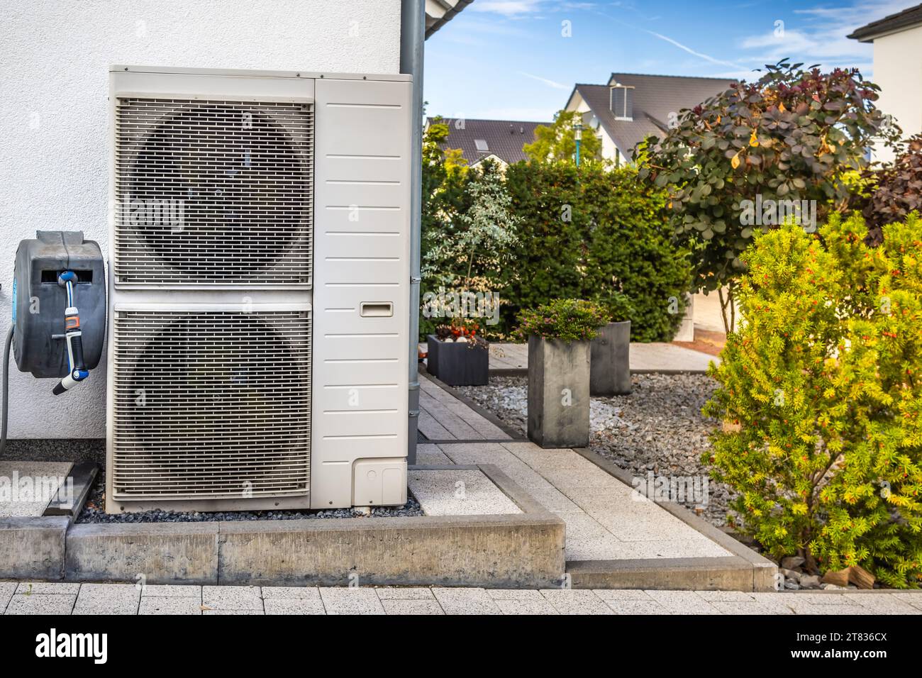 Two air source heat pumps installed outside of modern family house, green renewable energy concept of heat pump Stock Photo
