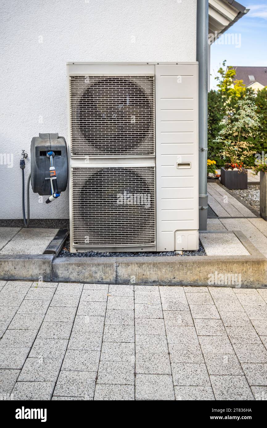 Two air source heat pumps installed outside of modern family house